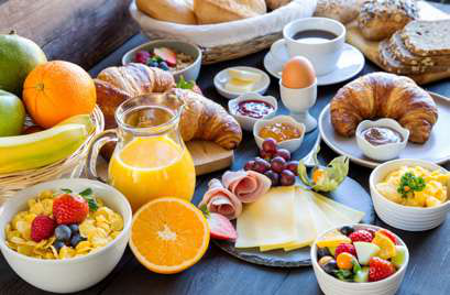 Frühstück mit Croissants, Obst und Kaffee